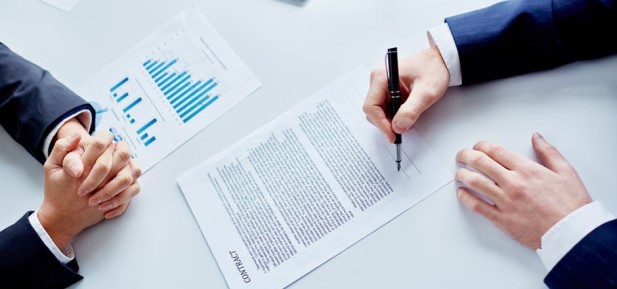 Mężczyzna podpisujący umowę 